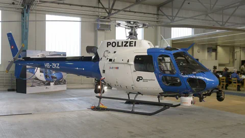 Blauer Polizeihubschrauber in Halle geparkt.