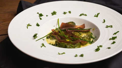 Capuns auf einem weissen Teller angerichtet. Das wahrscheinlich bekannteste Rezept aus Graubünden