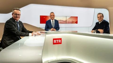 Drei Männer am RTR-Nachrichtentisch im Studio.