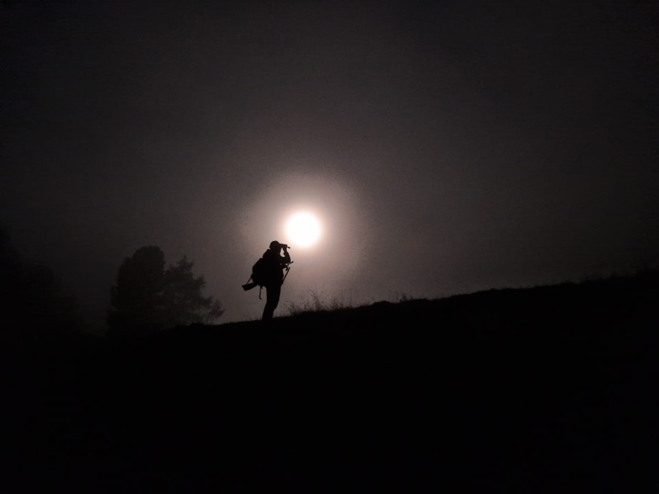 Ein Jäger in der Morgendämmerung und bei Vollmond.