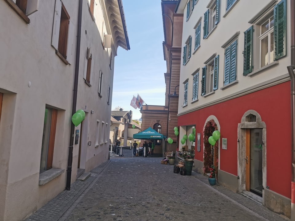 Eine Gasse mit grünen Ballonen. 