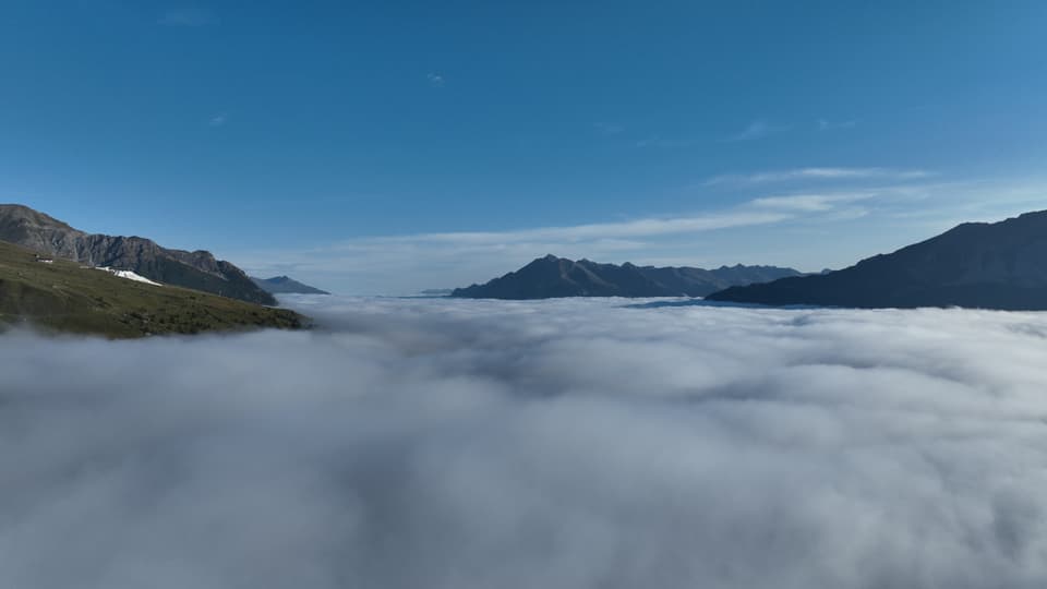 Sicht über ein grosses Nebelmeer und einige Berge und Bergflanken, die herausragen.