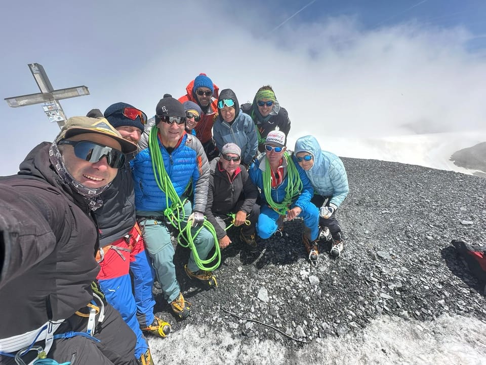 Besteigung Piz Russein / Tödi: Gruppe von Bergsteigern am Gipfel eines verschneiten Berges.