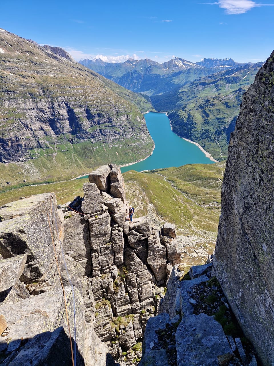 Blick von einem Felsen auf einen Bergsee in den Alpen.