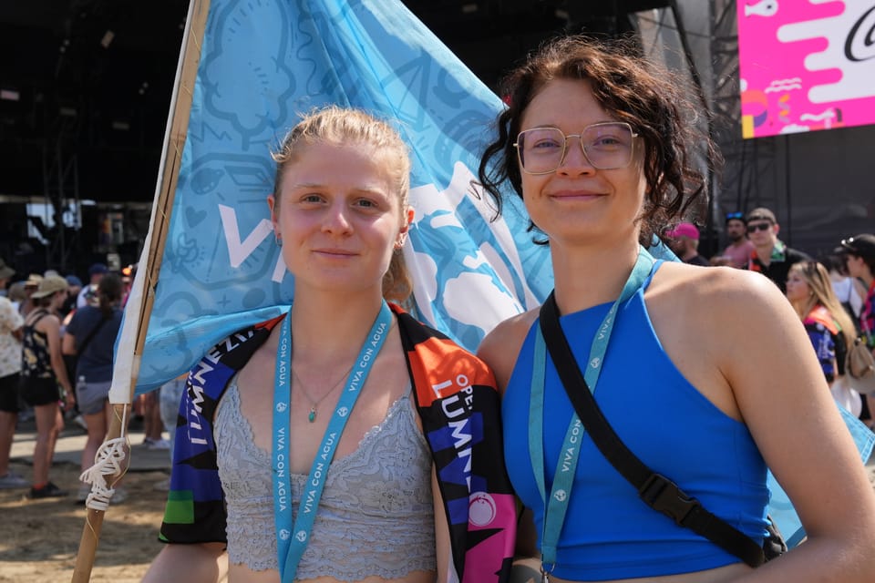 Zwei Frauen mit blauen Bändchen und Fahne bei einem Outdoor-Event am Open Air Lumnezia 2024.