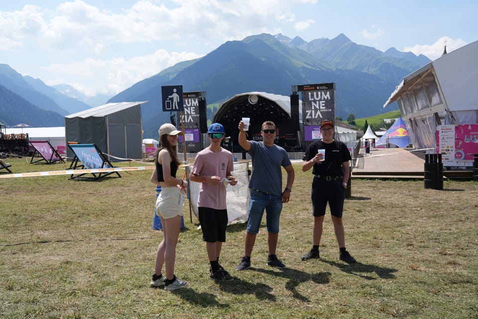 Vier Personen beim Musikfestival Lumnezia mit Bergen im Hintergrund.