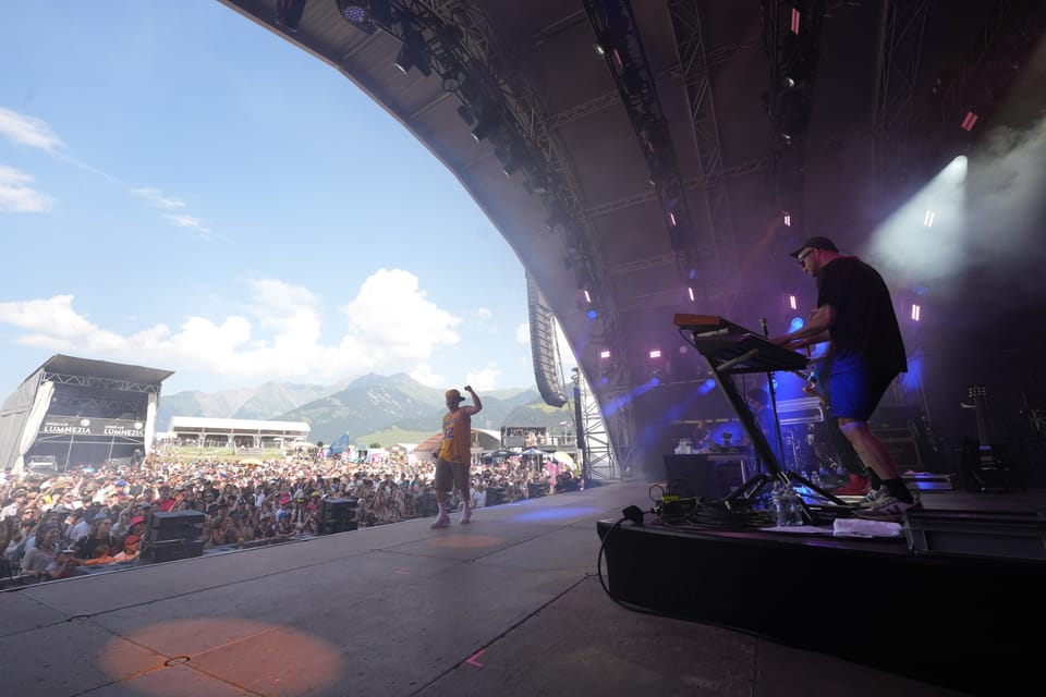 Konzertbühne mit Performer und Keyboarder, Menschenmenge im Freien EAZ am Open Air Lumnezia 2024.