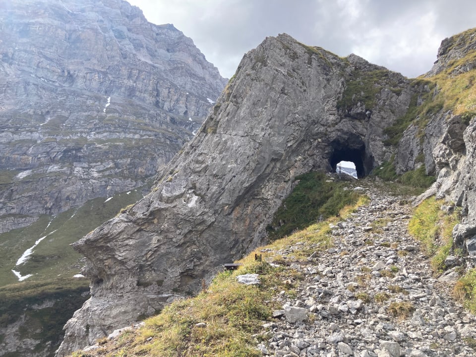 Bergpfad mit steinernem Tor und Berg im Hintergrund.