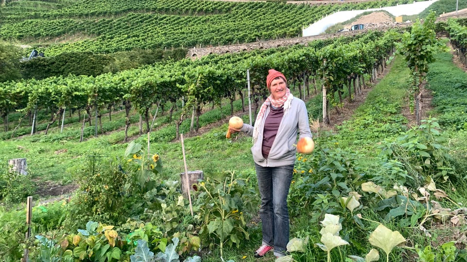 Die Leiterin von HEKS Gärten in Chur, Karin Roth, mit ihren frisch geernteten Kürbissen.