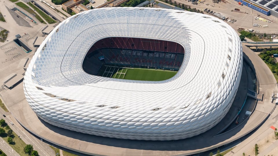Luftaufnahme eines modernen Fussballstadions mit weisser Fassade.