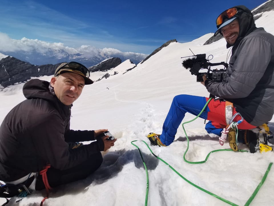Besteigung Piz Russein / Tödi: Zwei Männer auf einem schneebedeckten Berg, einer hält eine Kamera.