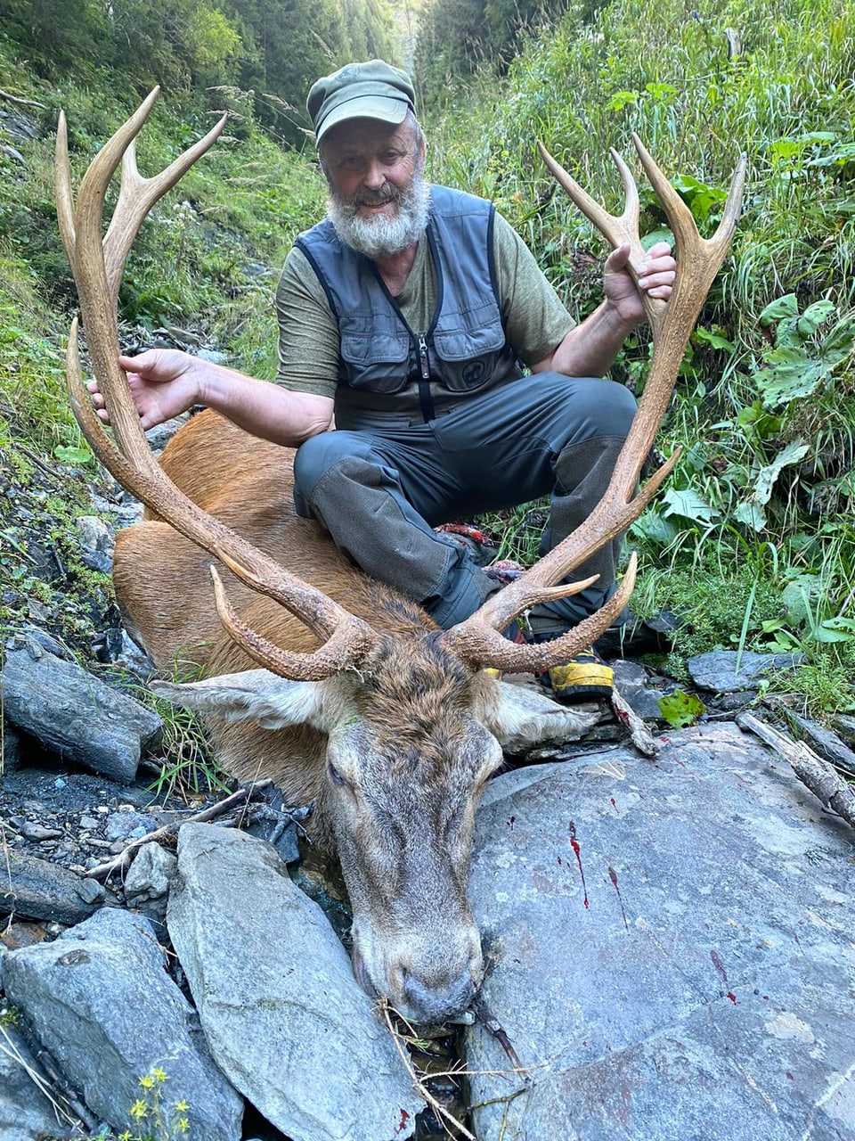 Ein Bündner Jäger mit einem mächtigen Hirsch.