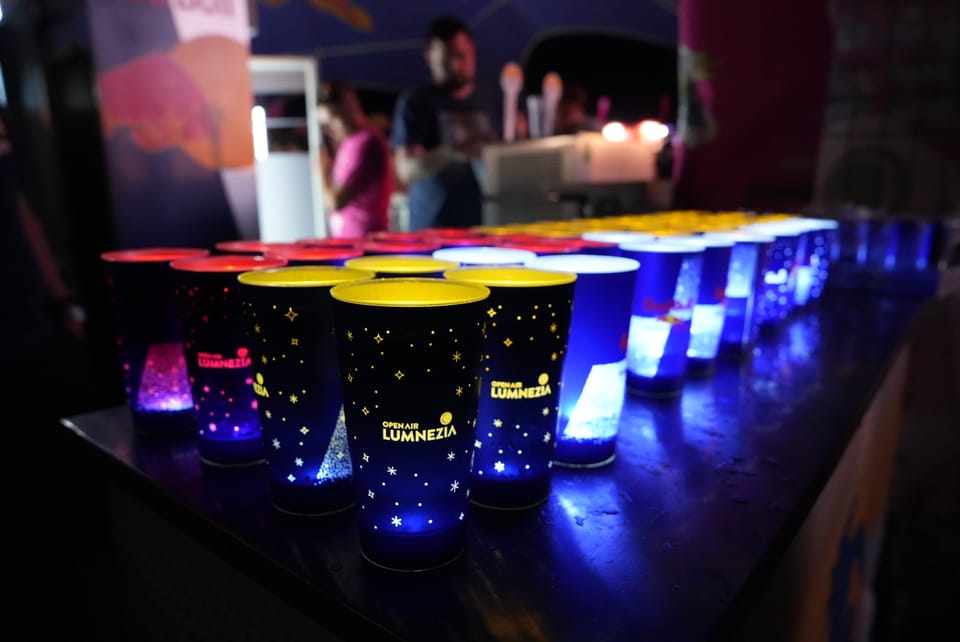 Leuchtende Becher auf einem Tisch bei Nacht am Open Air Lumnezia 2024..