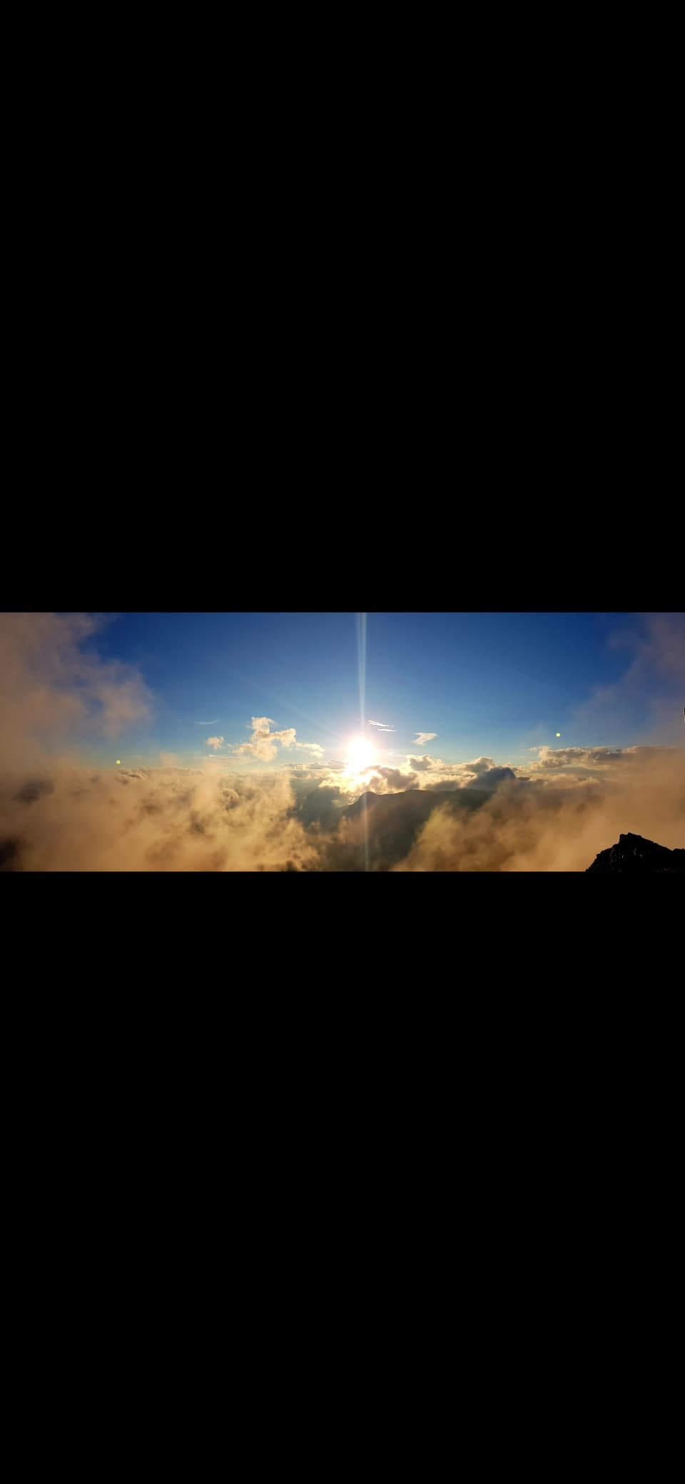 Die Sonne geht auf über den Bergen, begleitet von viel Nebel