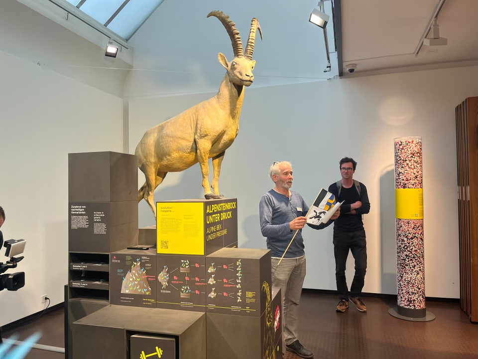 Eine Statue von einem Steinbock, daneben Flurin Camenisch