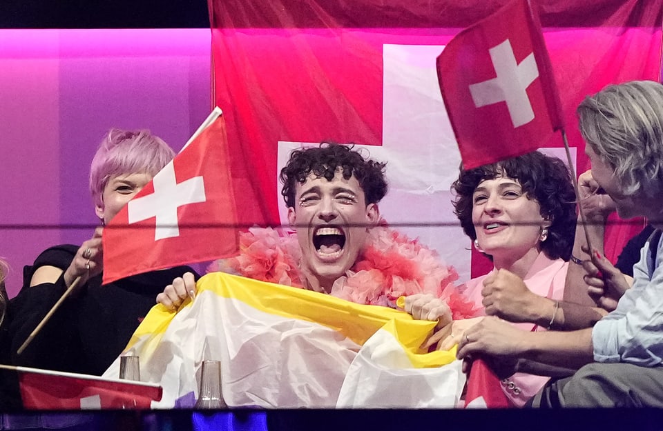 Fröhliche Menschen mit Schweizer Flaggen feiern.