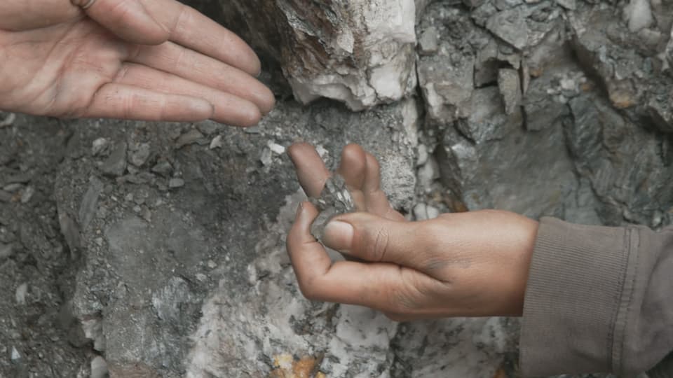 Eine Kinderhand hält einen Kristall.