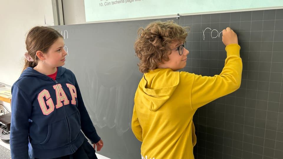 Foto von zwei Kindern an einer Wandtafel in der Schule.