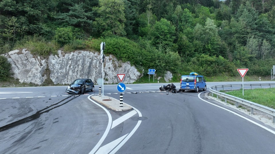 Verkehrsunfall mit Auto, Motorrad und Lieferwagen auf Landstrasse bei Wald.