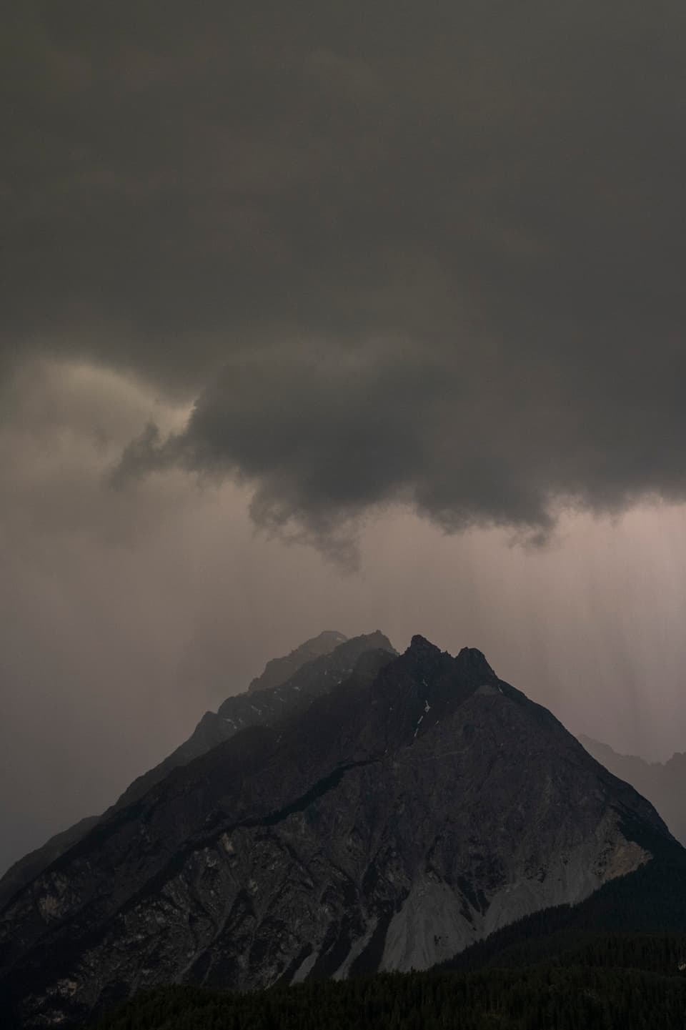 Ein Wolkenbruch mit Regen zieht über den Piz Pisoc und verwandelt die Landschaft in ein dramatisches Naturschauspiel.