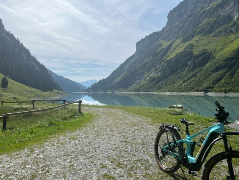 Mountainbike am Seeufer in alpiner Landschaft.