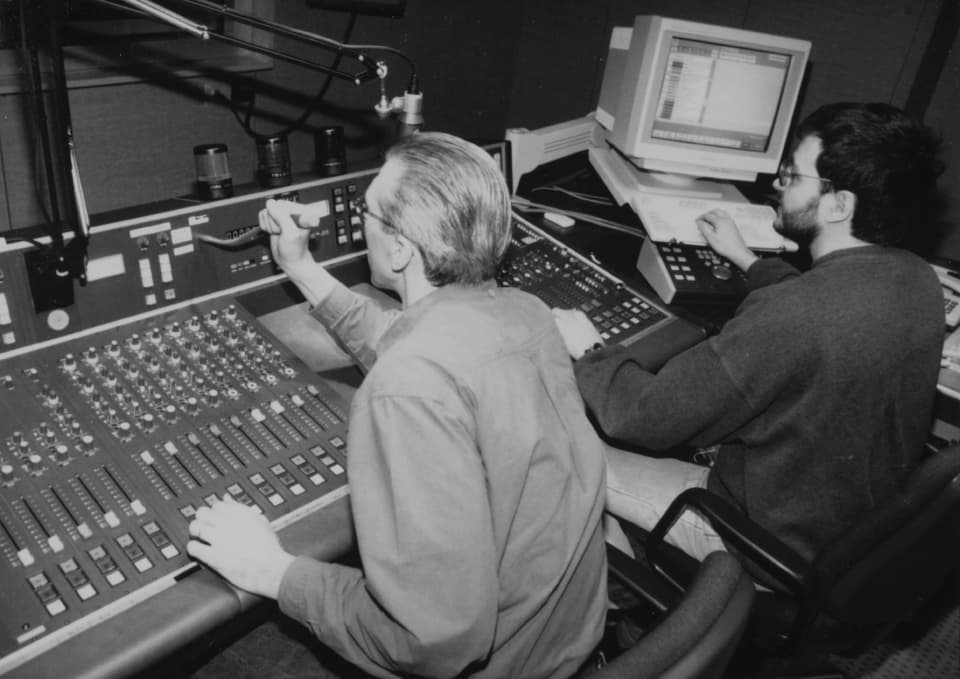 Zwei Männer arbeiten an einem Mischpult in einem Aufnahmestudio.