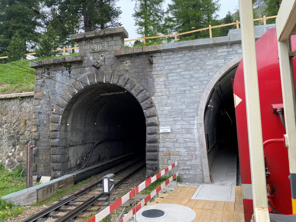 Eingang zu zwei Bahntunneln, einer mit Gleisen und ein weiterer Fussgängertunnel.