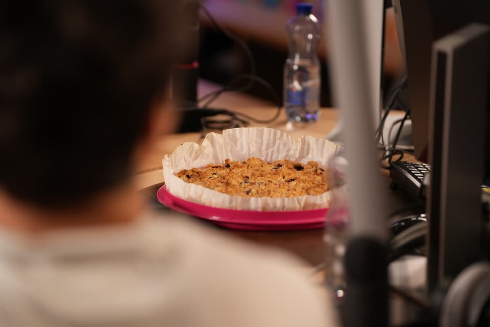 Person vor einem Tisch mit Kuchen auf einem Tisch.