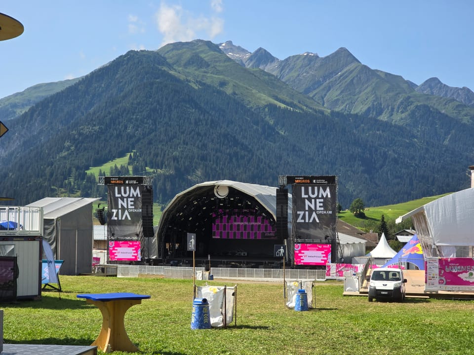 Sommer-Musikfestivalbühne im Tal mit Alpen im Hintergrund am Open Air Lumnezia 2024.