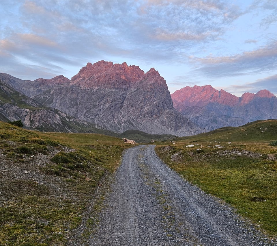 Schotterweg in den Bergen bei Sonnenuntergang.