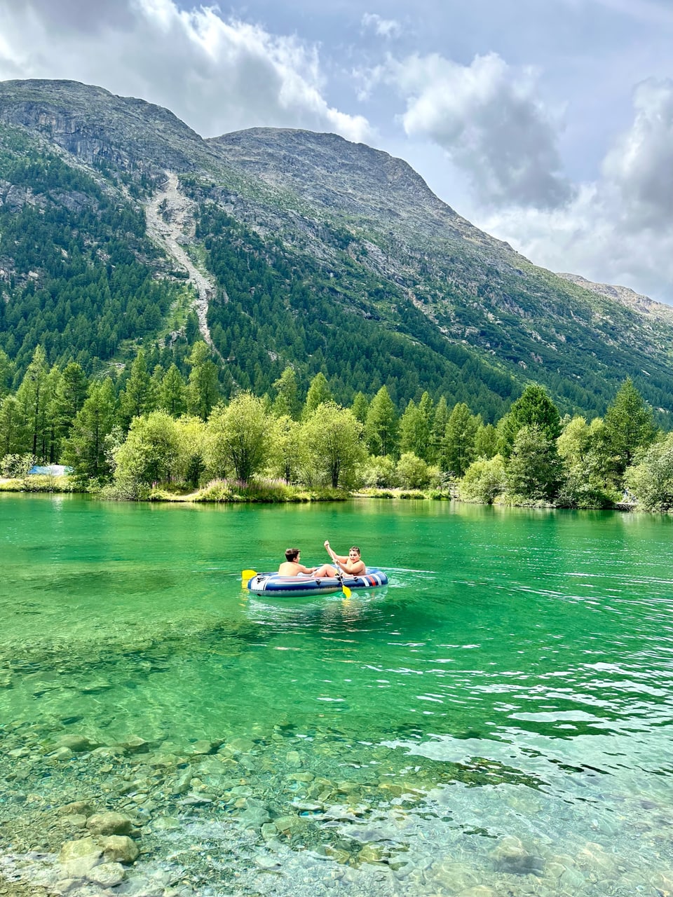 Zwei Menschen auf einem Schlauchboot auf einem See in den Bergen.