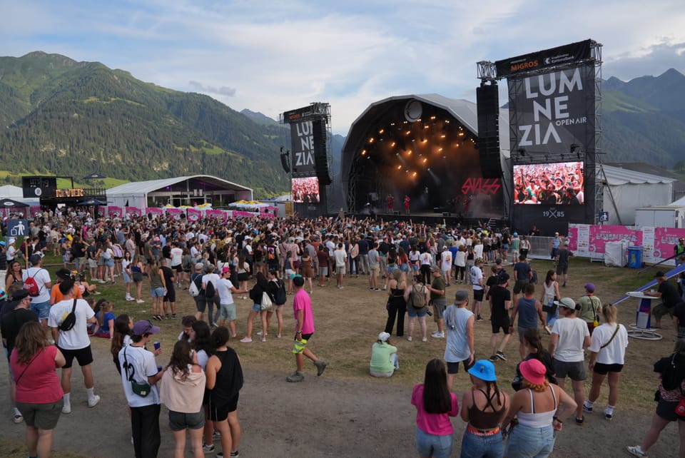 Menschenmenge vor einer Open-Air-Bühne bei einem Musikfestival in den Bergen am Open Air Lumnezia 2024 in Degen..