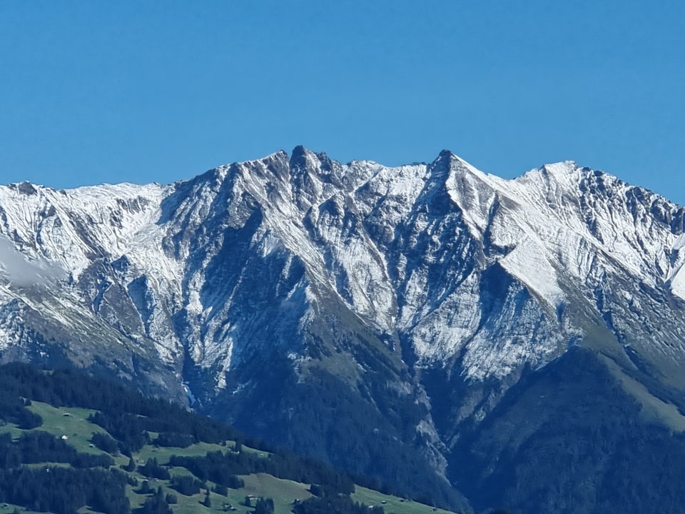 Schneebedeckter Berg unter blauem Himmel.