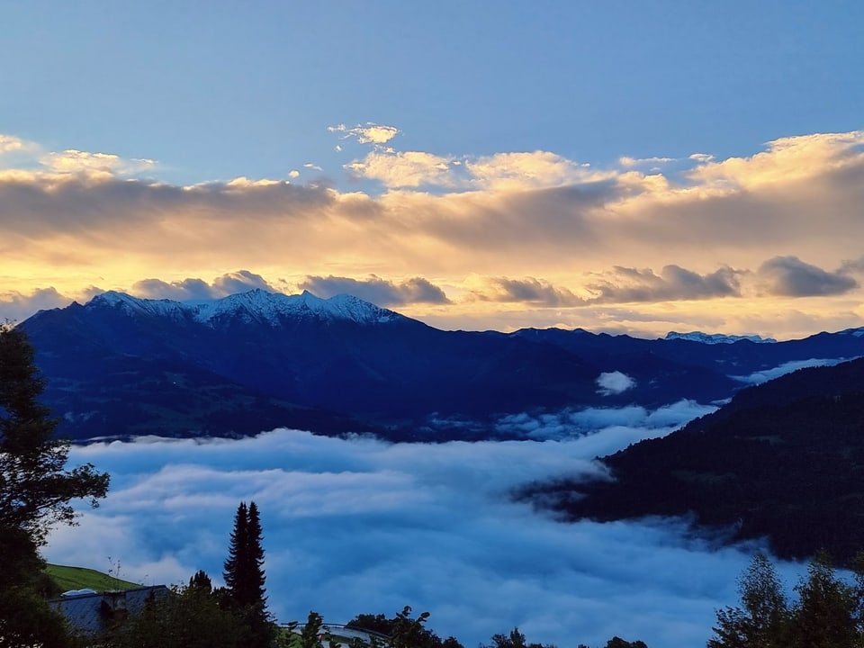 Berglandschaft mit Wolkenmeer und Schnee.