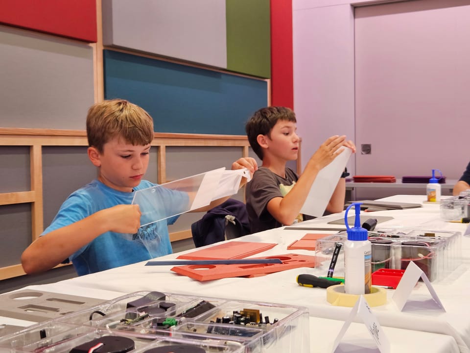 Ferienpass Domat/Ems: Radio DAB+ bei RTR bauen. Die Kinder halten ihre selbstgemachten Radios in den Händen
