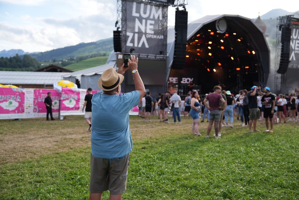 Mann fotografiert Konzertbühne beim Lumnezia Openair-Festival.
