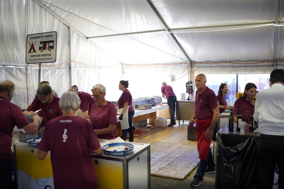 Freiwillige Helferinnen und Helfer arbeiten in der Küche während des Mittagsessens.