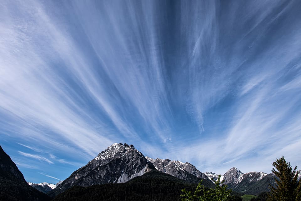 Ein faszinierendes Wolkenspiel umhüllt den Piz Pisoc und verleiht der Berglandschaft einen mystischen Charakter.