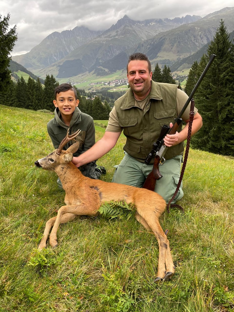 Bündner Jäger Christoph Jacomet mit seinem Sohn und dem Rehbock.