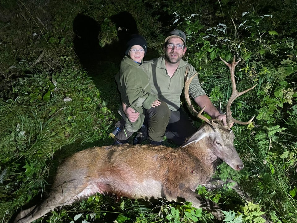 Bündner Jäger Mitgel Arpagaus und sein Sohn Nando mit dem geschossenen Hirsch.