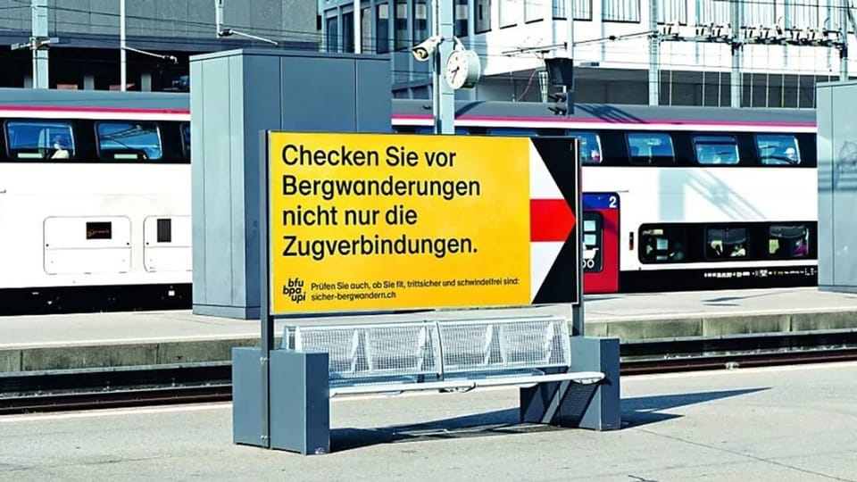 Plakat am Bahnsteig mit dem Text 'Checken Sie vor Bergwanderungen nicht nur die Zugverbindungen.'