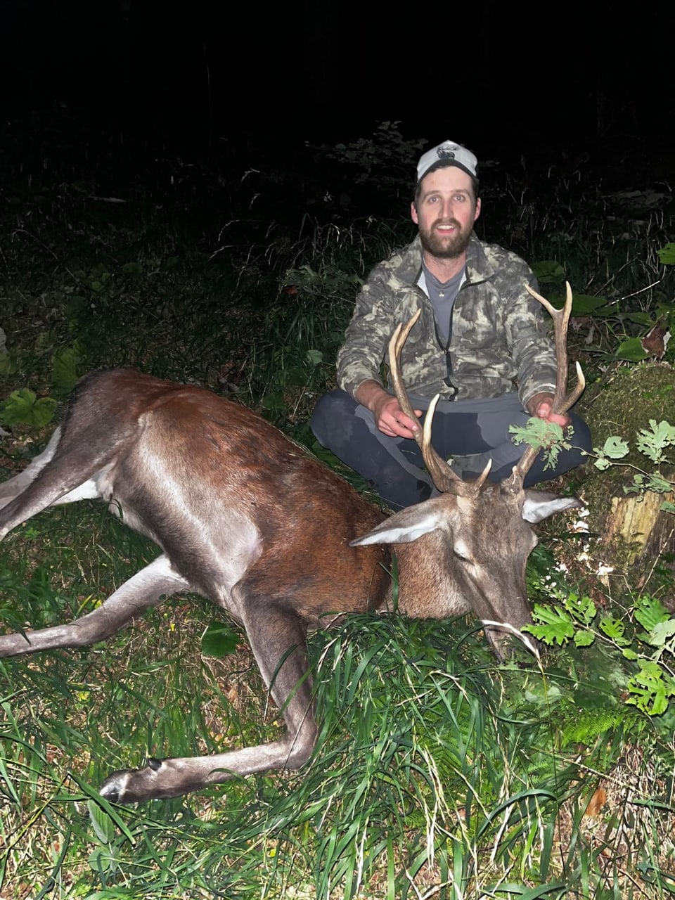 Jäger mit erlegtem Hirsch im Wald