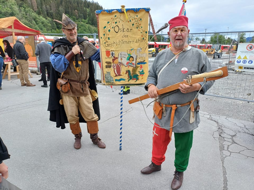 Zwei Männer in mittelalterlichen Kostümen mit einem Schild.