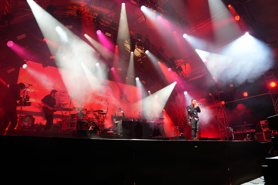 Musikband auf der Bühne mit bunten Lichtern am Open Air Lumnezia 2024.