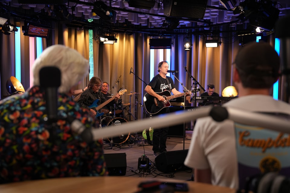 Eine Band spielt vor Zuschauern in einem Studio.