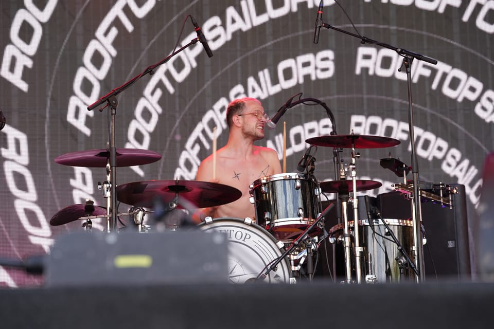 Mann spielt Schlagzeug auf einer Bühne.