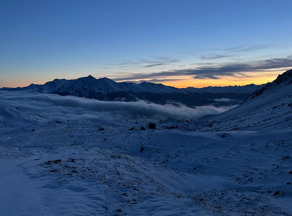 Schneebedeckte Berglandschaft bei Sonnenaufgang.