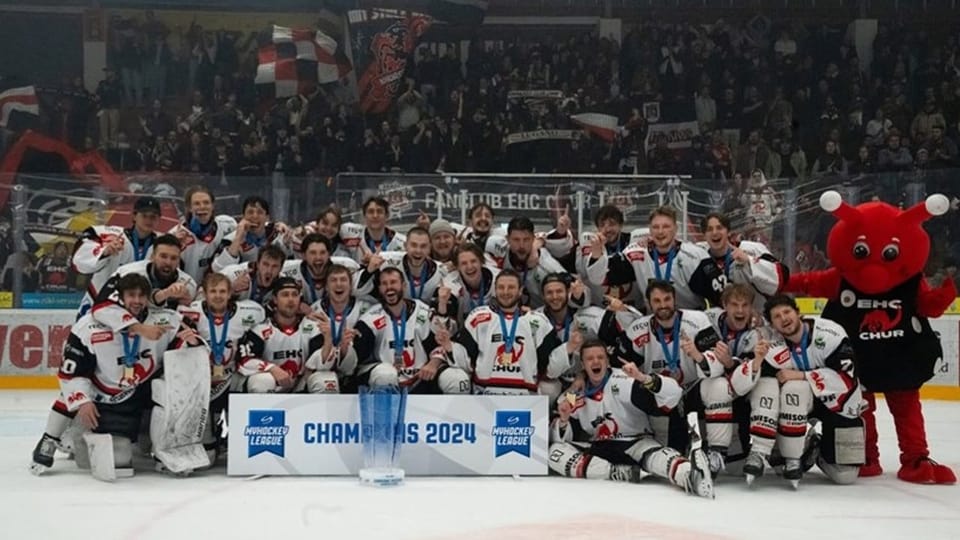 Eishockeymannschaft feiert Meisterschaft 2024 mit Pokal und Maskottchen.