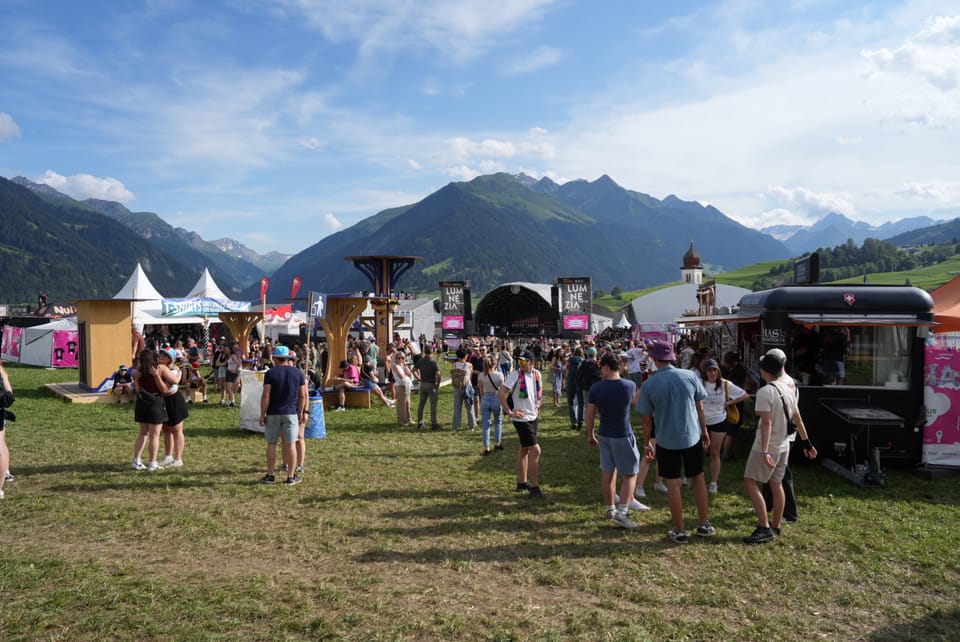 Menschen beim Festival Open Air Lumnezia 2024 in den Alpen vor Degen.